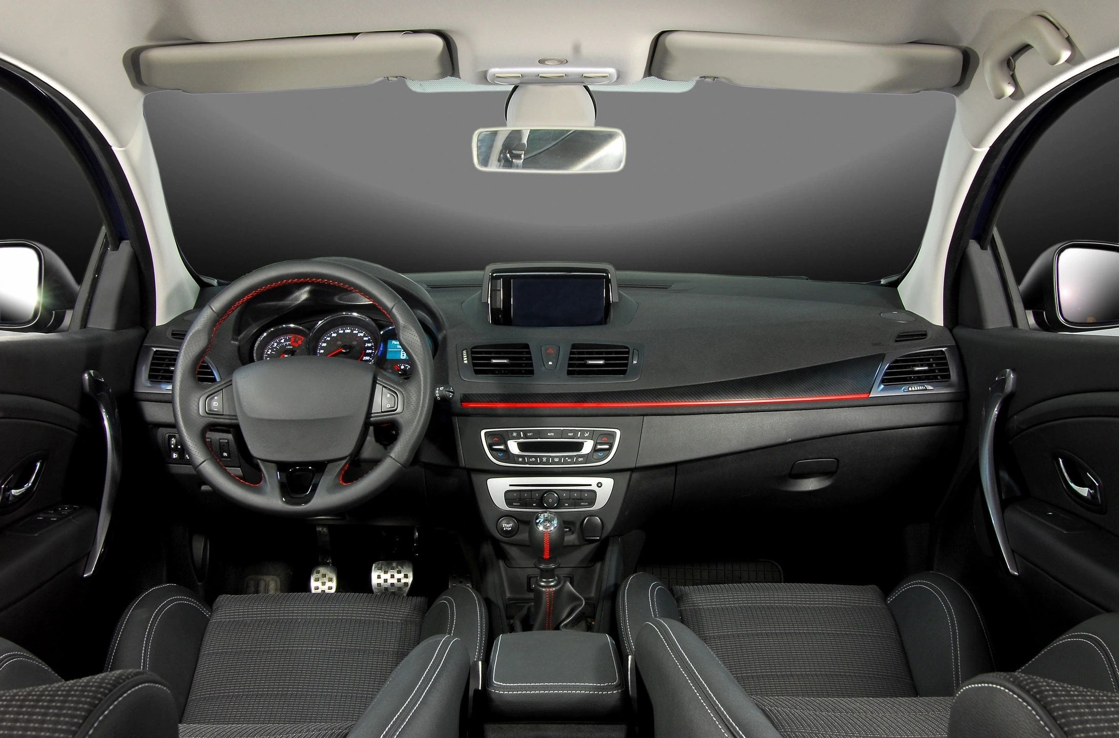 A car dashboard with the steering wheel and dashboard lights on.