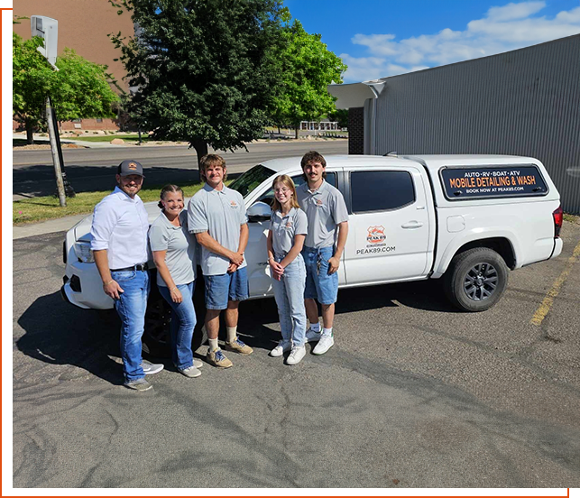 A group of people standing in front of a truck.